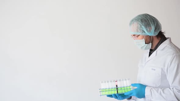 A Doctor in a White Coat and Protective Mask with a Test Tubes Holder.