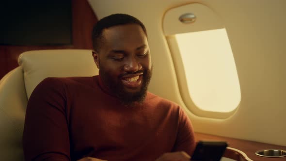 Cheerful Man Texting Friend at Plane Window Closeup