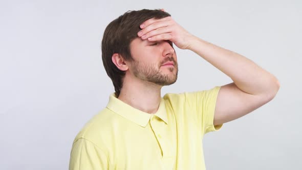 Handsome Beared Man Checking Body Temperature with Arm on His Forehead Isolated on Grey