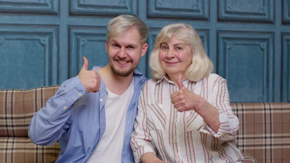 Family of Senior Grayhaired Mother and Handsome Adult Son or Grandson Showing Thumbs Up Gesture