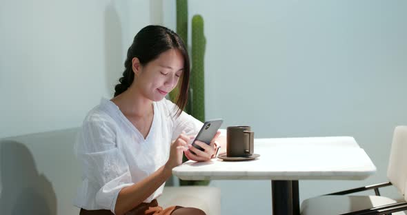 Woman use of mobile phone in coffee shop