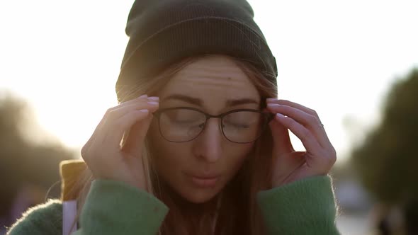 Portrait of a Young Beautiful Woman Outdoors in Winter Putting on Headphones