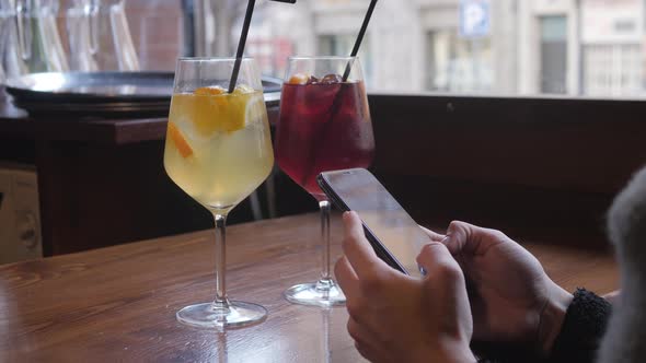 Traveler Woman Drink Sangria and Using Smartphone in Spanish Cafe Girl with Phone Use Application