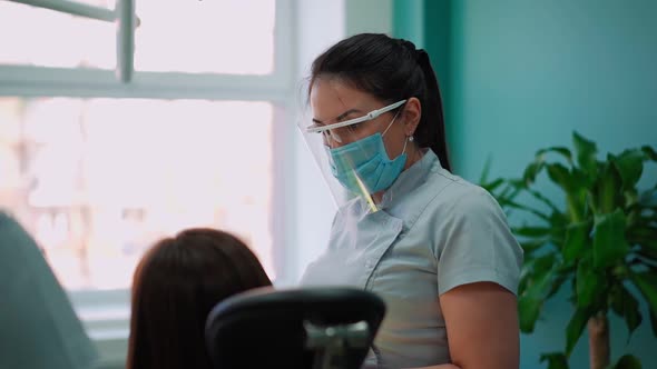 Woman Doctors in Protective Masks in Dental Clinic Serve Patient