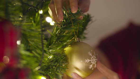 Asian female decorated with ornament on Christmas tree at Christmas night and New Year festival.