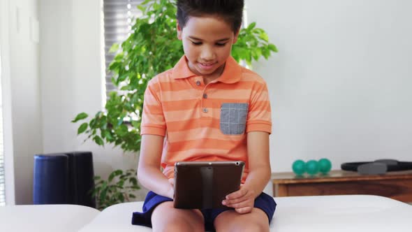 Boy using digital tablet on bed