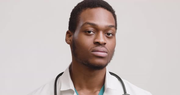 Studio Portrait of African American Medical Doctor, Turning Face To Camera and Widely Smiling