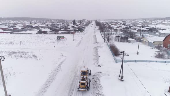 Aerial view of Snowblower Grader Clears Snow Covered Country Road in village 06