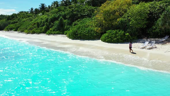 Sexy happy lady on photoshoot enjoying life on beach on clean white sand and blue 4K background