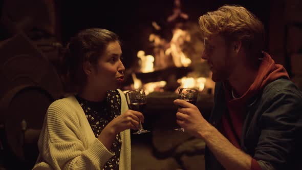 Resting Couple Drink Wine By Cozy Fireplace