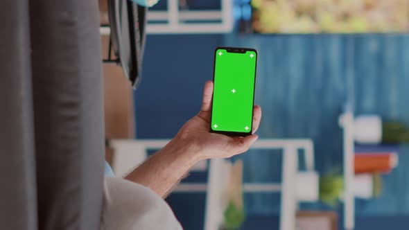 Static Tripod Shot of Couple Enjoying Social Media Videos on Smartphone with Green Screen