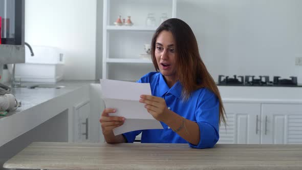 Happy Attractive Young Woman Reading Pleasant News in Letter Postal Correspondence Feeling Excited