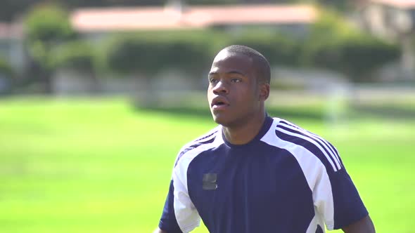 A man playing soccer on a grassy field.