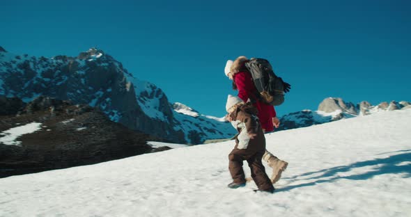 Family Walk on Snow at Vacation Mountain Travel Holding Hands