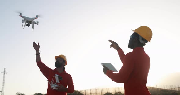 Multiracial engineer men working together on a windmill farm with digital tablet and drone