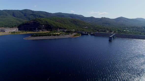 Wide of dam and reservoir, with mountains in the background