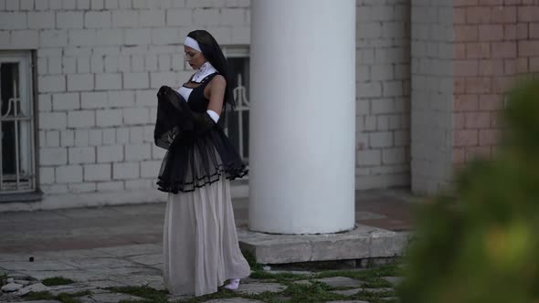 Fantasy Shot of Sinful Nun Lady in Erotic Gown is Walking Near Old Church Praying and Strolling