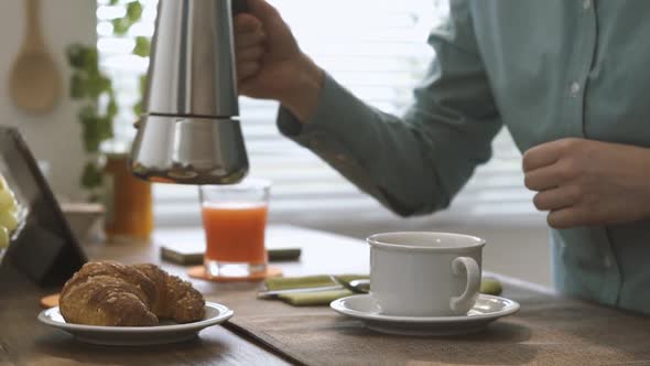 Woman pouring coffee in a cup