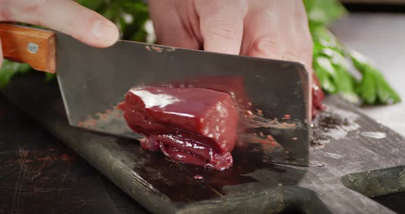 Raw Liver Cut Into Pieces with a Large Knife. 