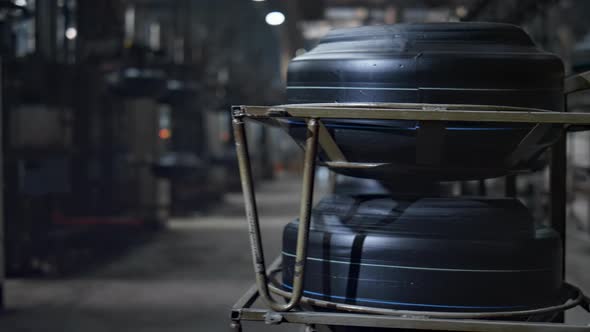 Car Tire Plant Storage View with Worker Silhouette Walking at Modern Factory