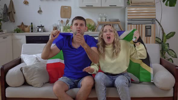 A Family of Sports or Football Fans of the South African National Team Watch TV at Home