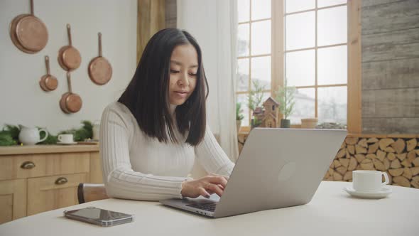 Young Adult 20s Woman Happy Scrolling on Her Laptop in Her Apartment