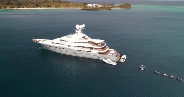 Superyacht on anchor in Tonga. Pan around - wide angle