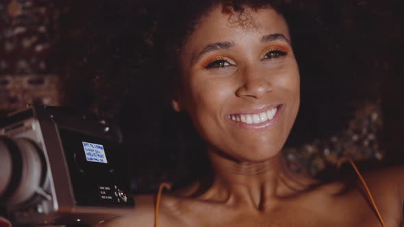 Woman With Afro Hair Smiling With Vintage 8Mm Camera