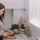 Young female cutting tomatoes in the kitchen. Chopping vegetables for salad - VideoHive Item for Sale