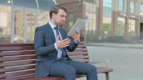 Upset Businessman Reacting to Loss on Tablet Outdoor