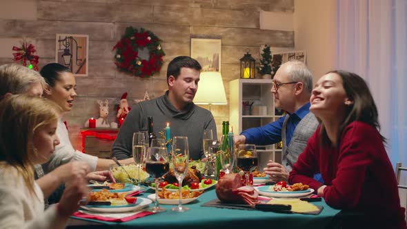 Little Daughters Sitting at the Table with Adults