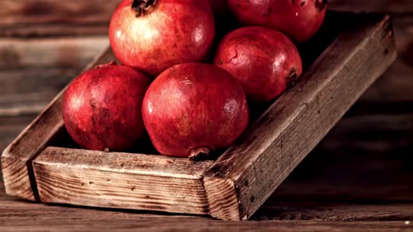 Super Slow Motion Wooden Tray with Pomegranates Falls on the Table