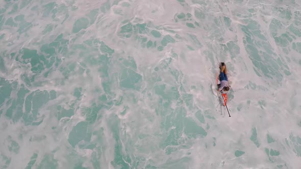Aerial view of a man paddling while sup stand-up paddleboard surfing in Hawaii.
