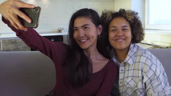 Asian and African American Black Woman Taking Selfie Using Smartphone