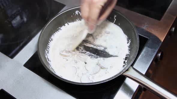 A Chef Prepares Cream Pasta with Mushrooms in a Frying Pan