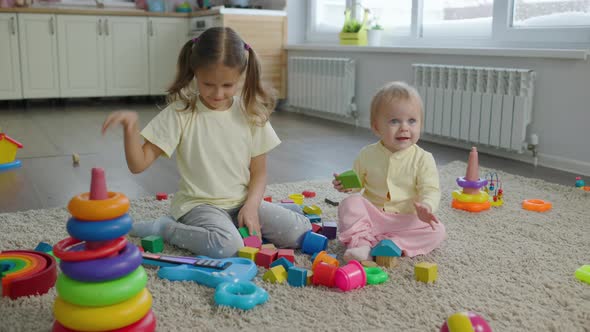 Two Sisters Girls Children Play Toys In The Room At Home