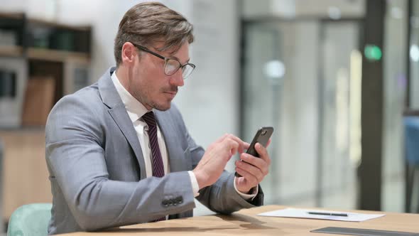 Businessman Using Smartphone in Office