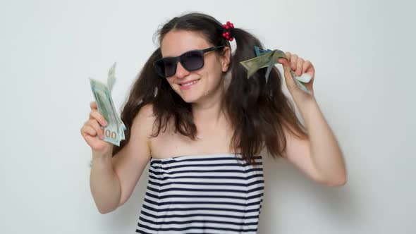 A Funny Woman Dances Holding a Lot of Money in Her Hands Throws Money Up