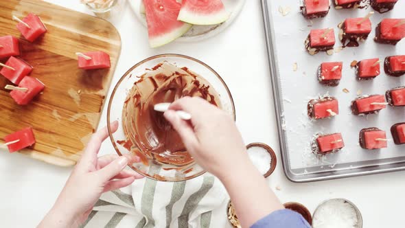 Step by step. Dipping watermelon cubes into melted chocolate and garnishing with sea salt and almond