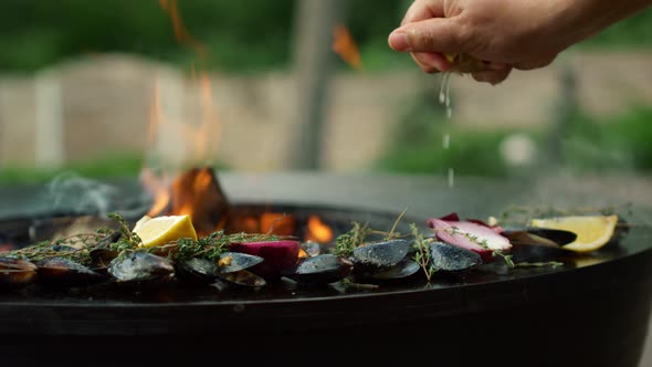 Man Squeezing Lemon on Seafood on Grill