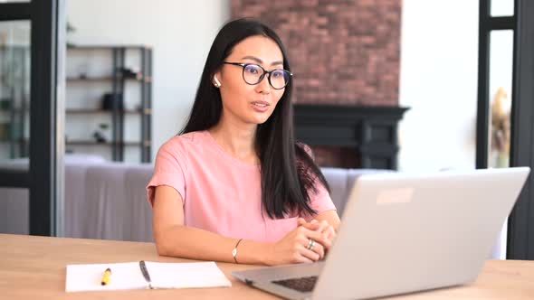 An Attractive Young Asian Woman is Using a Laptop for Video Call