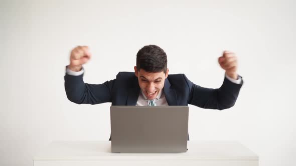 Happy Office Worker Works at Laptop and Funny Rejoices at Successful Deal