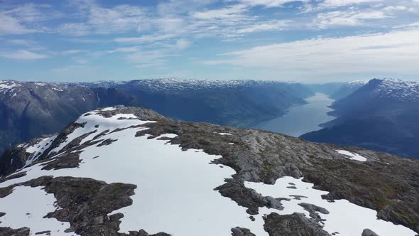 Aerial orbiting view epic mountain Oksen with snow, fjord Background - Norway.