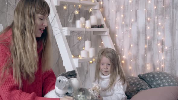 Mother and Daughter Spend Time Playing with Toy Sheep