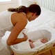 Tired mother putting baby in bassinet and lying on bed - VideoHive Item for Sale