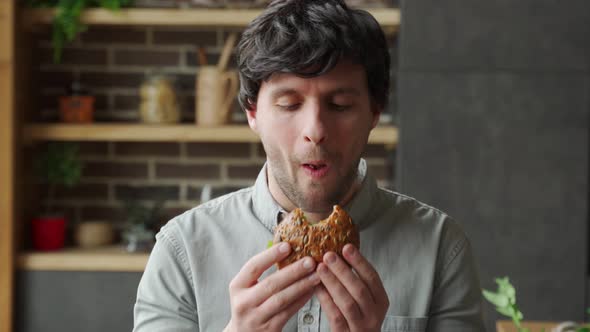 Hungry Man Eating Burger at Home Kitchen