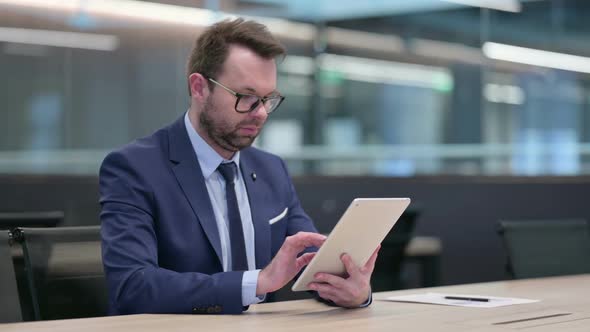 Middle Aged Businessman Using Digital Tablet