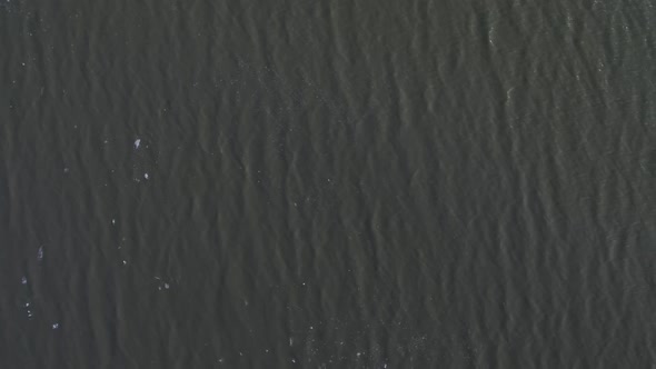 Aerial view flying over lake passing over broken ice