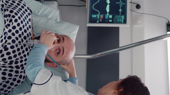 Vertical Video Sick Man Resting in Bed While Woman Medic Putting Oxygen Mask