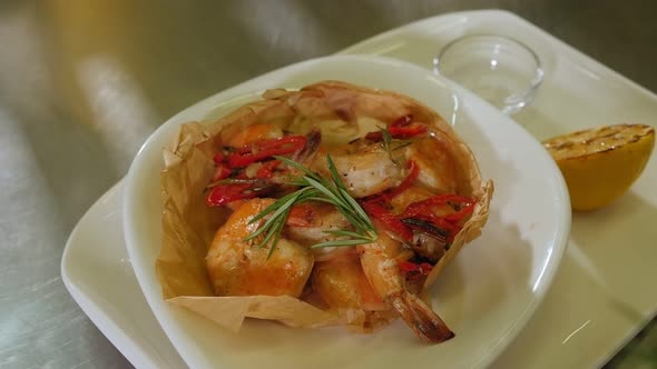 Closeup of the Chef Putting a Sprig of Rosemary in a Plate with Prawns